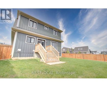 A house with a grey and white exterior and a wooden fence in the background.