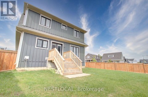 A house with a grey and white exterior and a wooden fence in the background.