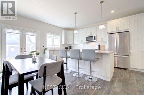 A modern kitchen with a dining table and chairs.