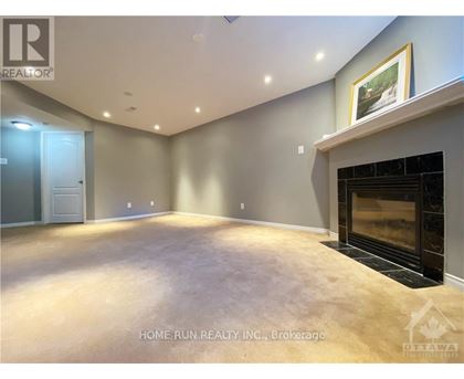 A spacious living room with a fireplace and a painting on the wall.