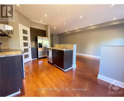 A kitchen with dark wood floors and white walls.