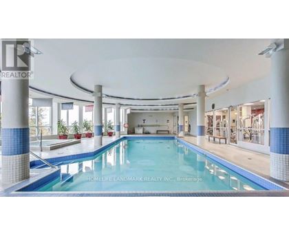 A swimming pool inside a building with a sign that says "HOMELIFE LANDMARK REALTY INC., Brokerage".