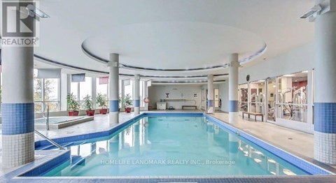 A swimming pool inside a building with a sign that says "HOMELIFE LANDMARK REALTY INC., Brokerage".