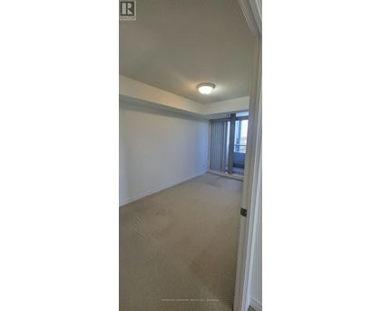 A room with a carpeted floor and a window with curtains.