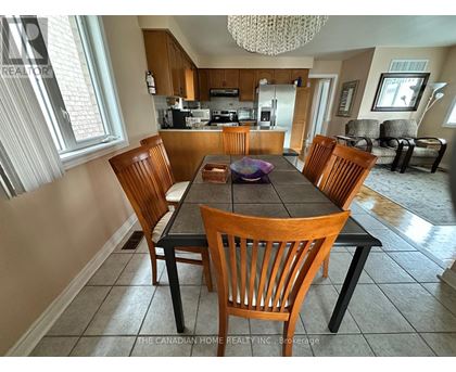 A dining room with a table and chairs.