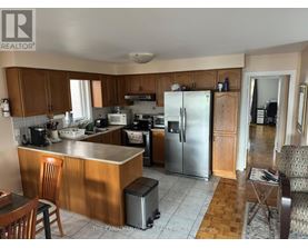 A kitchen with wooden cabinets and a refrigerator.