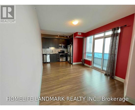 A spacious room with a kitchen area and a window with a view.