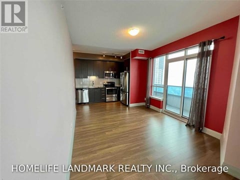 A spacious room with a kitchen area and a window with a view.
