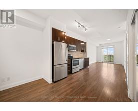A spacious kitchen with wooden floors and stainless steel appliances.