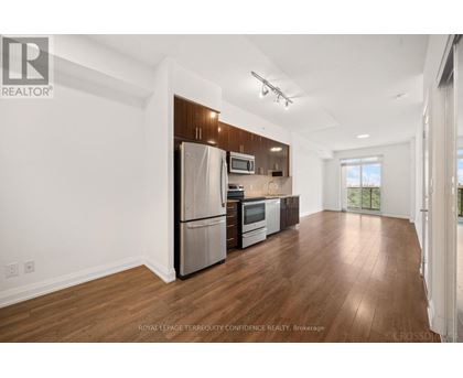 A spacious kitchen with wooden floors and stainless steel appliances.