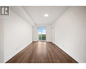 A room with wooden floors and white walls, with a window that shows a blue sky and greenery outside.