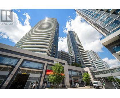 A modern building with a curved facade stands tall among other buildings.