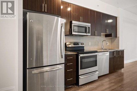 A kitchen with a stainless steel refrigerator and microwave.