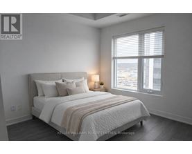 A bedroom with a large bed and a window with blinds.