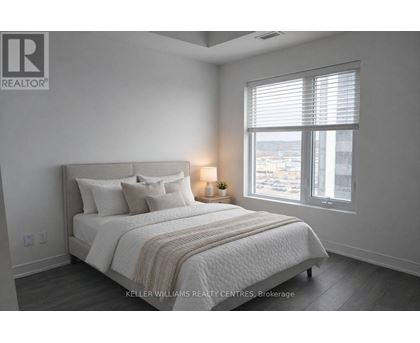 A bedroom with a large bed and a window with blinds.
