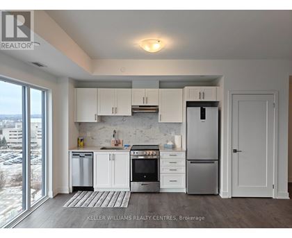A modern kitchen with white cabinets and stainless steel appliances.