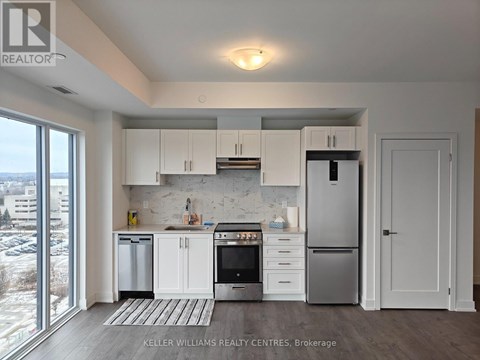 A modern kitchen with white cabinets and stainless steel appliances.