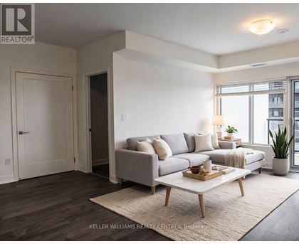 A living room with a grey couch, a wooden coffee table, and a rug.