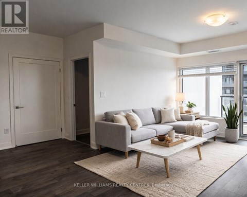 A living room with a grey couch, a wooden coffee table, and a rug.
