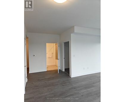 A spacious room with a doorway leading to another room.