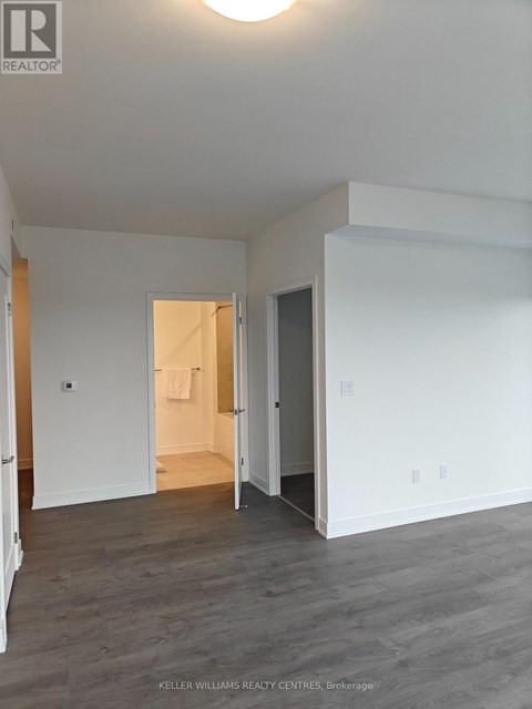 A spacious room with a doorway leading to another room.
