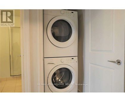 A white washing machine and dryer stacked on top of each other in a laundry room.