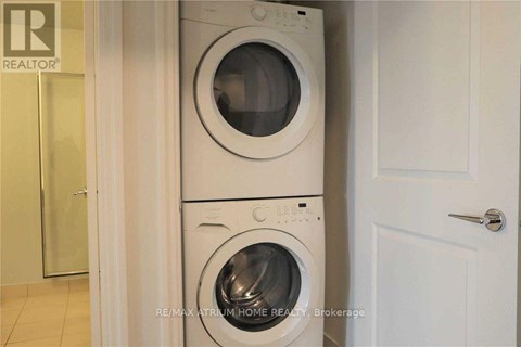 A white washing machine and dryer stacked on top of each other in a laundry room.