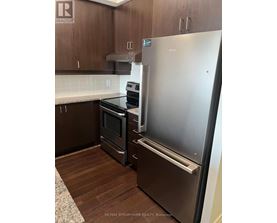 A kitchen with a stainless steel refrigerator and a stove.