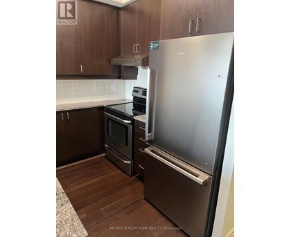 A kitchen with a stainless steel refrigerator and a stove.