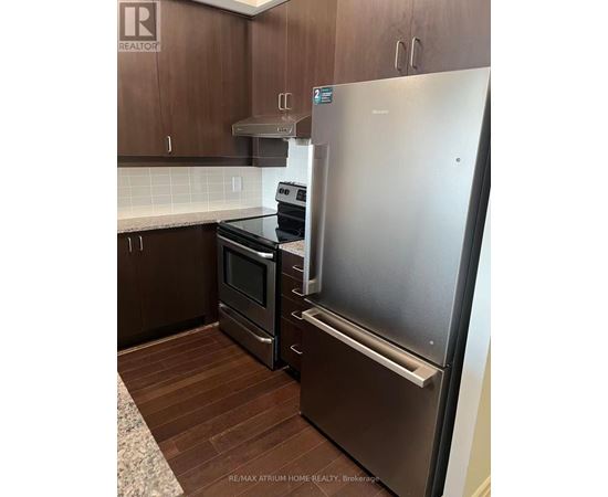 A kitchen with a stainless steel refrigerator and a stove.