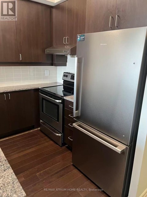 A kitchen with a stainless steel refrigerator and a stove.