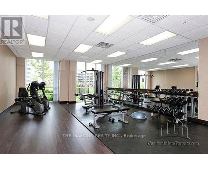 A gym with a variety of equipment including treadmills, weights and exercise machines.
