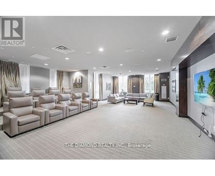 A spacious living room with a row of beige sofas and a television on the wall.