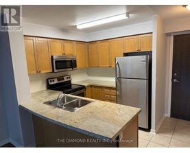 A kitchen with a sink, microwave, and refrigerator.