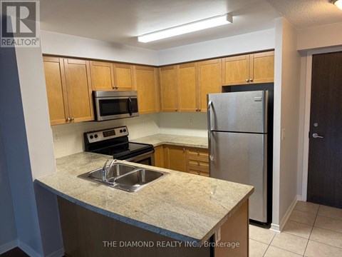 A kitchen with a sink, microwave, and refrigerator.