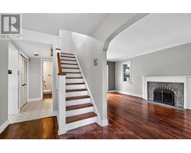 A spacious room with a staircase leading to the upper floor.
