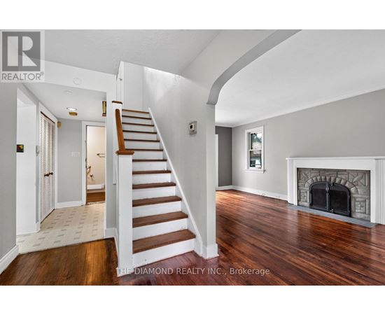 A spacious room with a staircase leading to the upper floor.