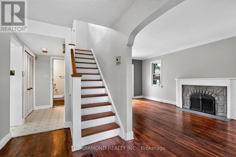 A spacious room with a staircase leading to the upper floor.