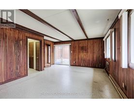 A large empty room with wooden walls and a white ceiling.