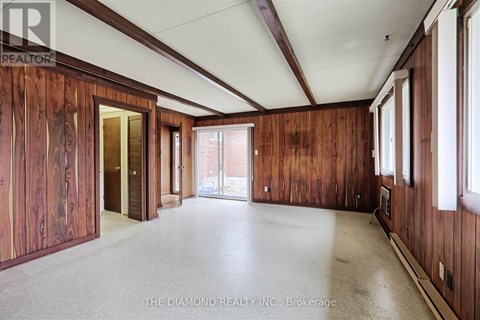A large empty room with wooden walls and a white ceiling.