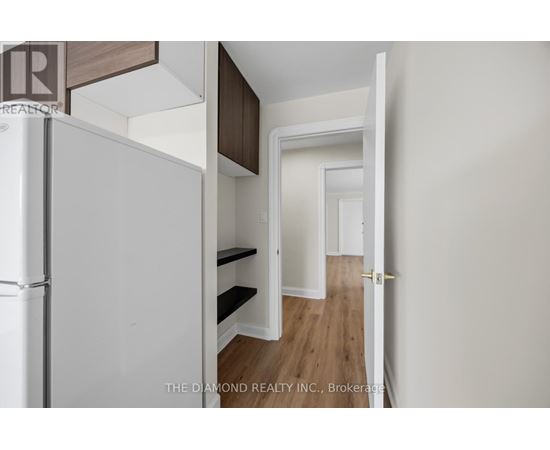 A white refrigerator is in a kitchen with a white door.