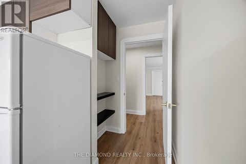 A white refrigerator is in a kitchen with a white door.