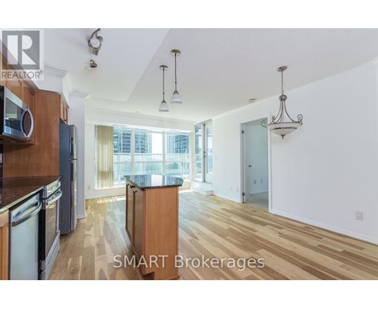 A kitchen with wooden floors and a large window.