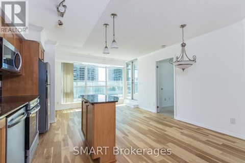 A kitchen with wooden floors and a large window.