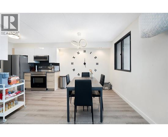 A kitchen with a dining table and chairs in the middle of the room.