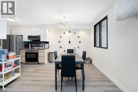 A kitchen with a dining table and chairs in the middle of the room.
