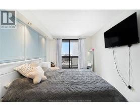 A bedroom with a large bed and a flat screen TV mounted on the wall.