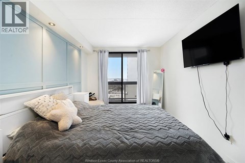 A bedroom with a large bed and a flat screen TV mounted on the wall.