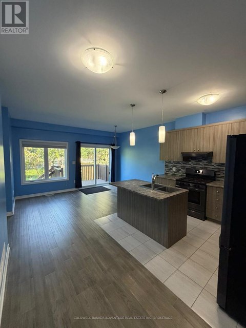 A kitchen with a sink and a stove top oven.