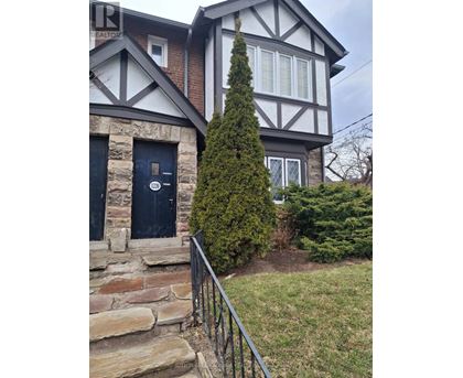 A house with a black door and a stone wall.